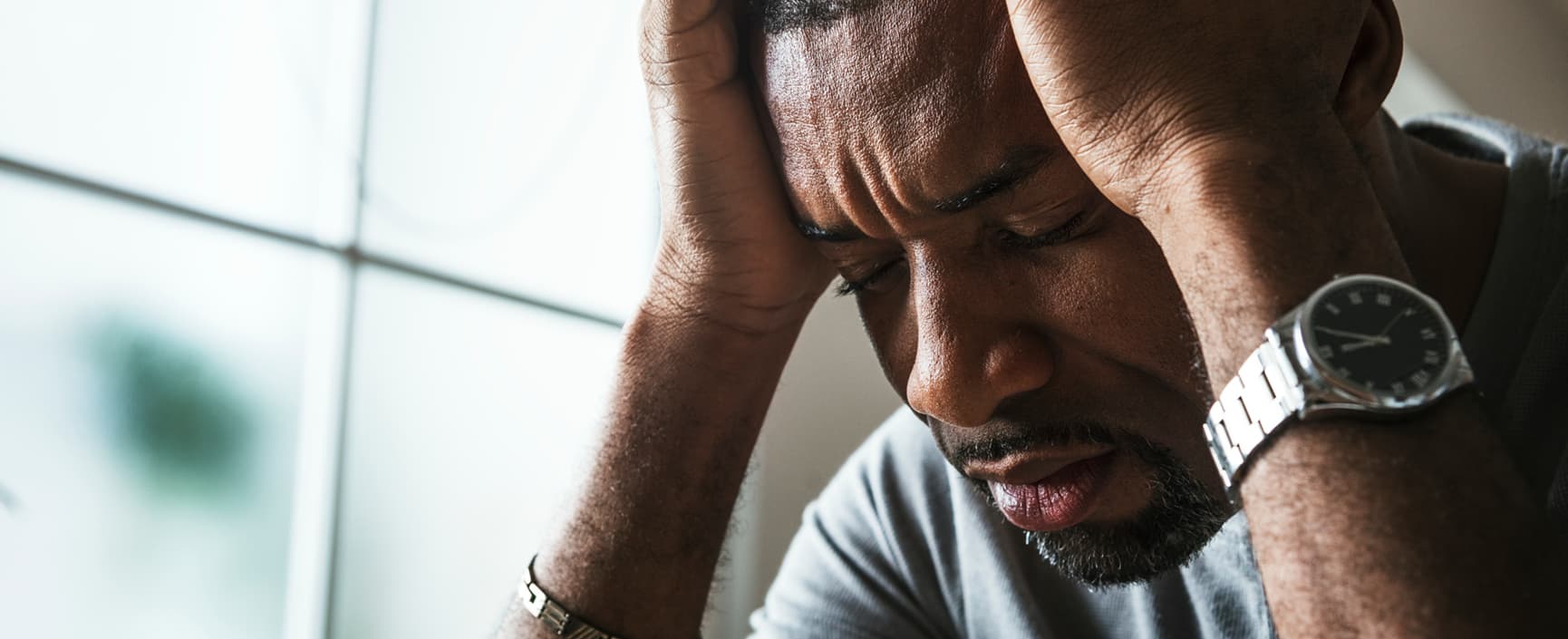 A man holding his head due to the headache