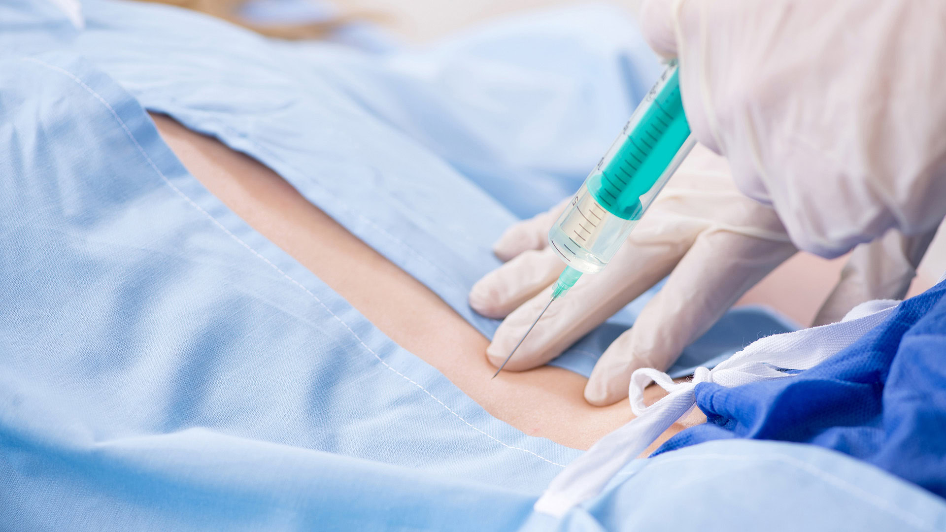 Female patient receiving injection in clinic on her back