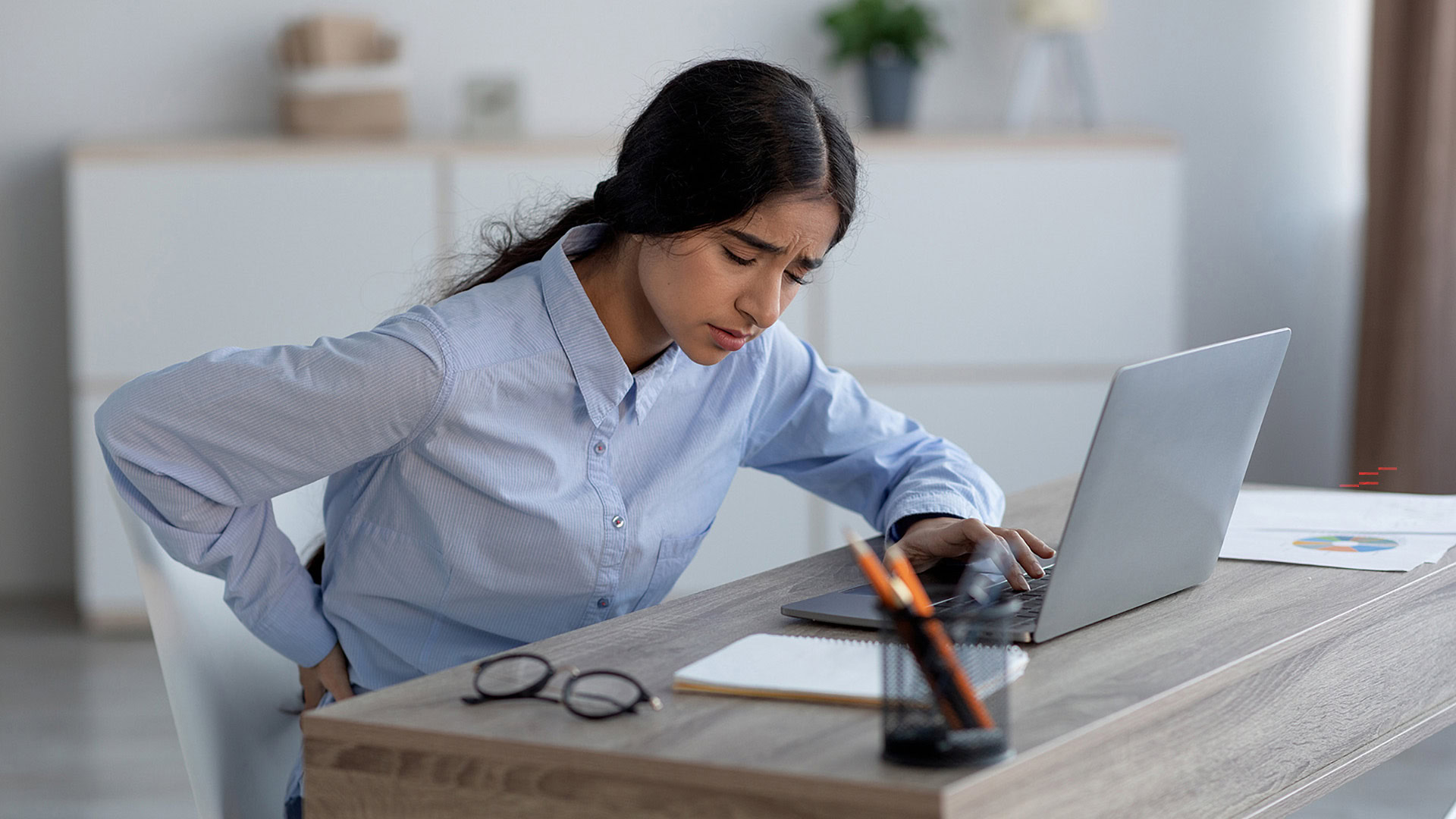 A women suffering from back pain at workplace