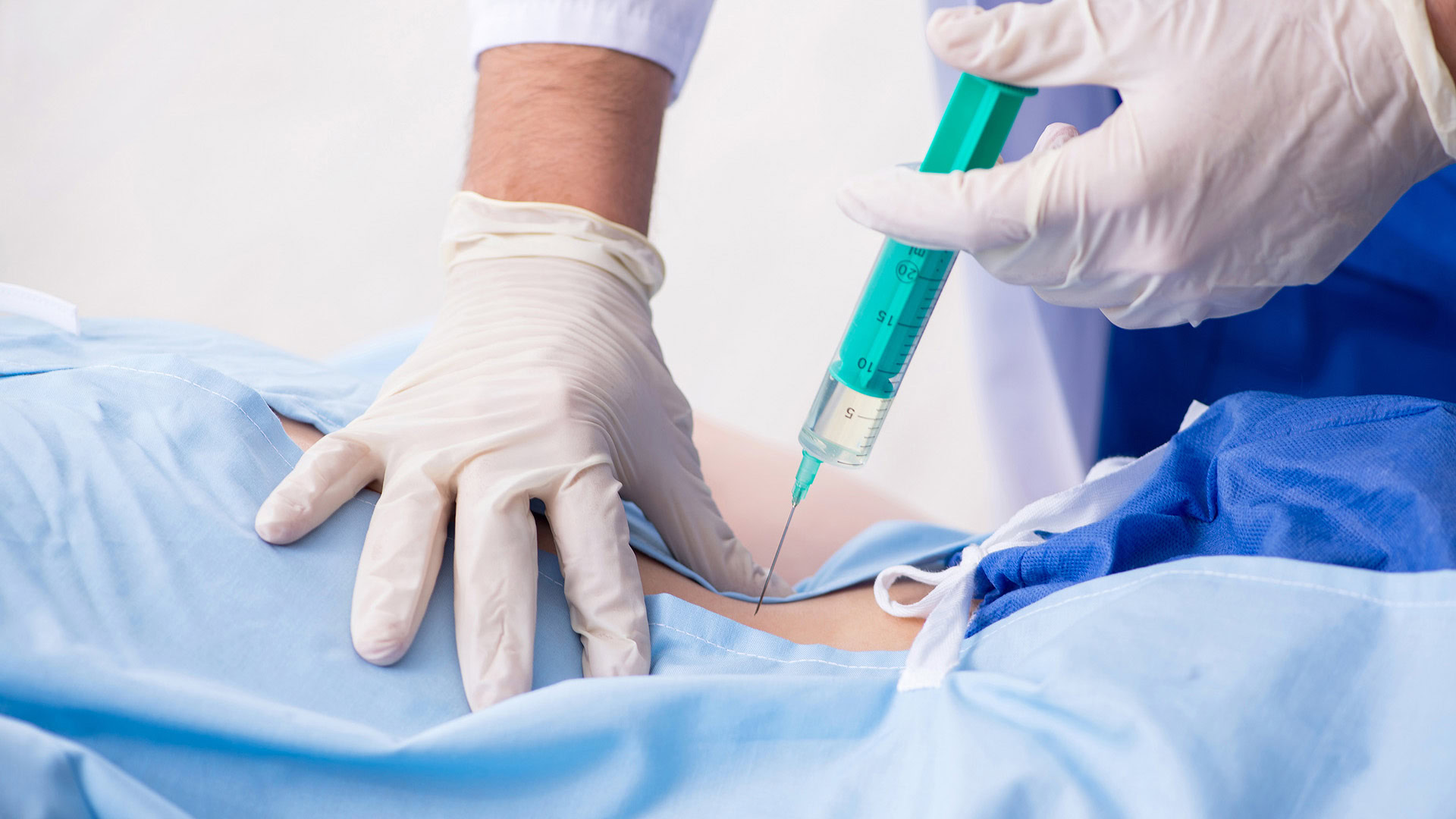 Female patient receiving injection in clinic on her back
