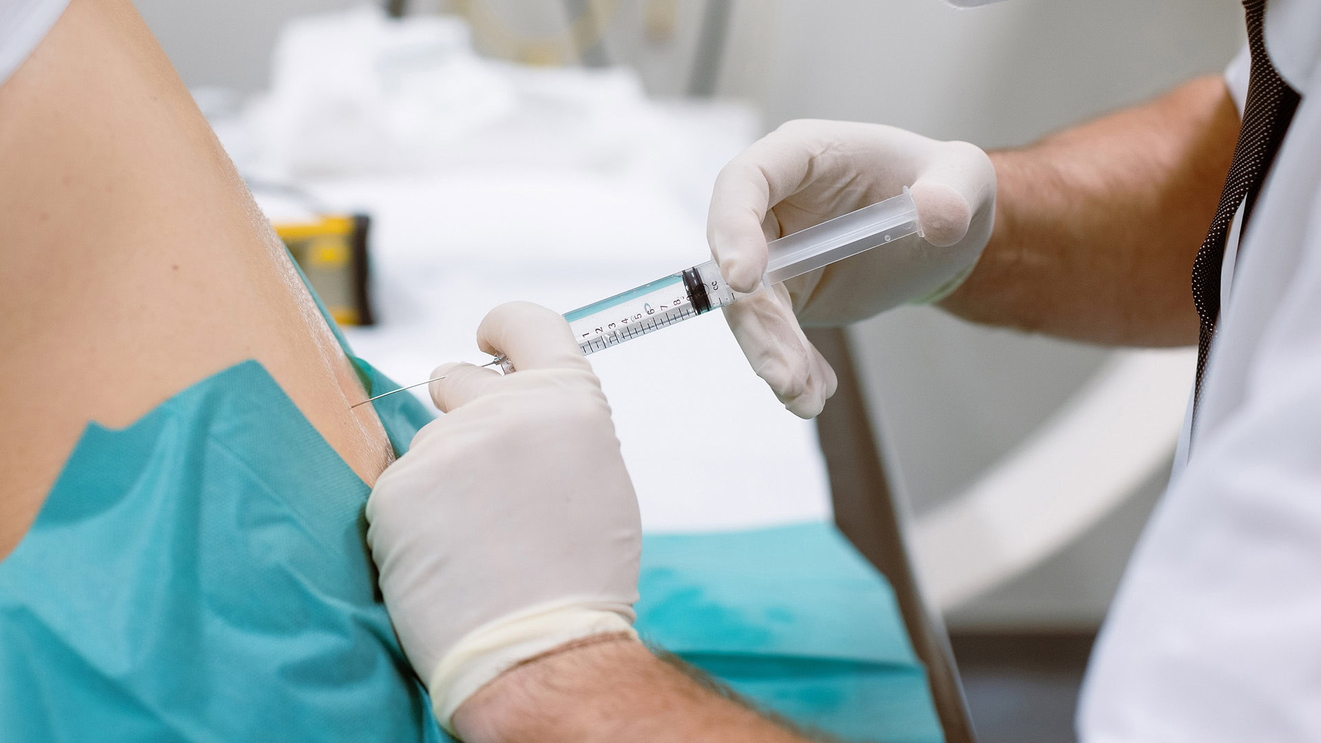 Doctor injecting cortisone for herniated disc treatment