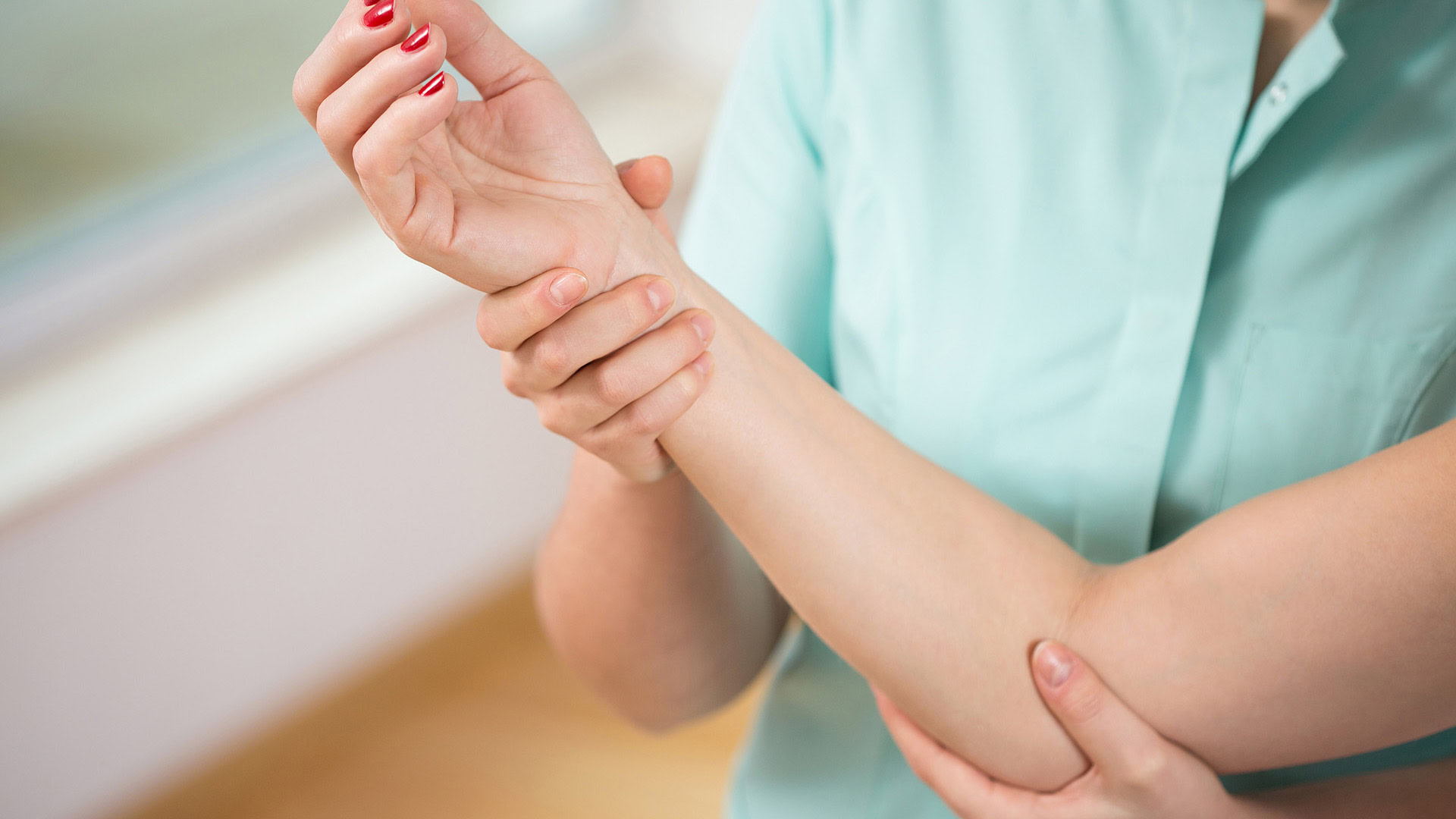 Doctor diagnosing painful elbow of young woman