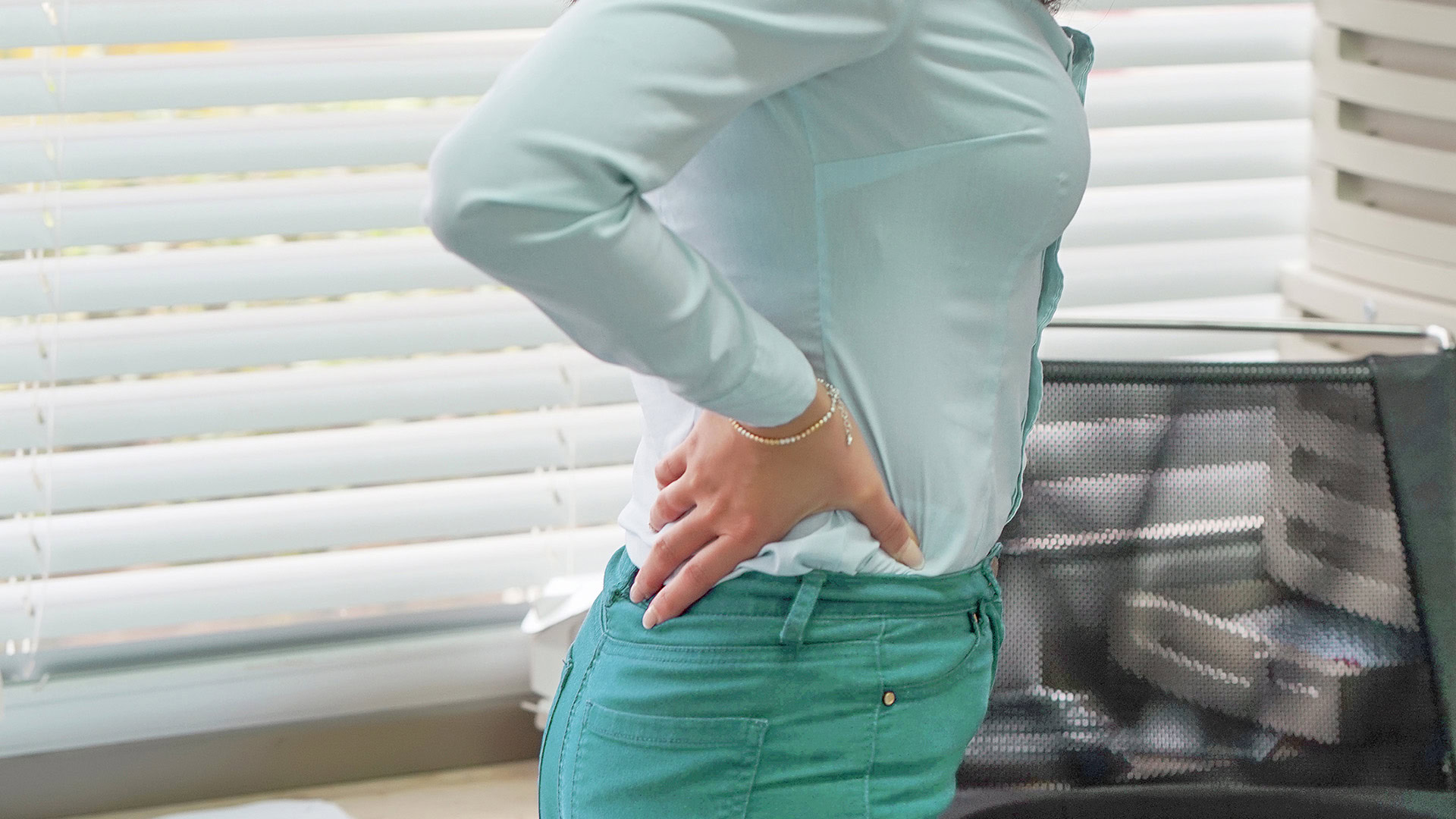 Woman experiencing lower back pain at work