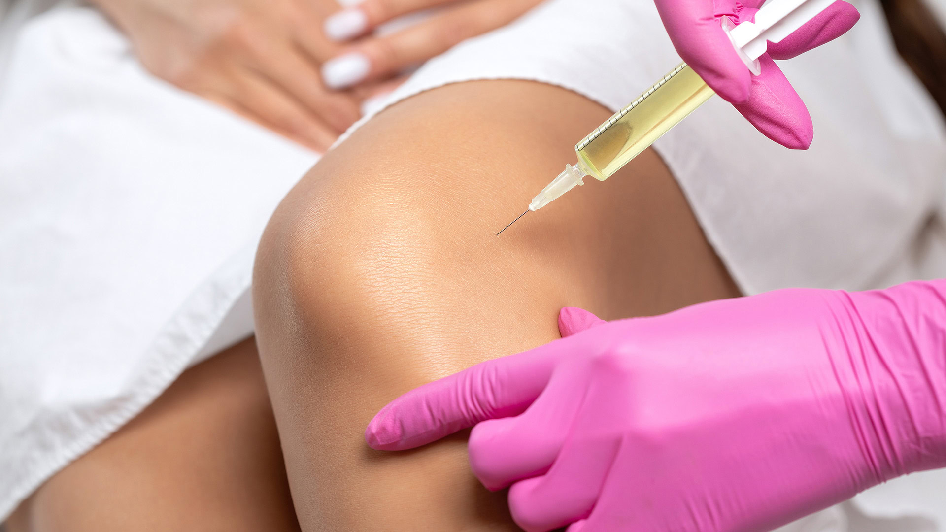Doctor administering stem cell injection to patient's knee