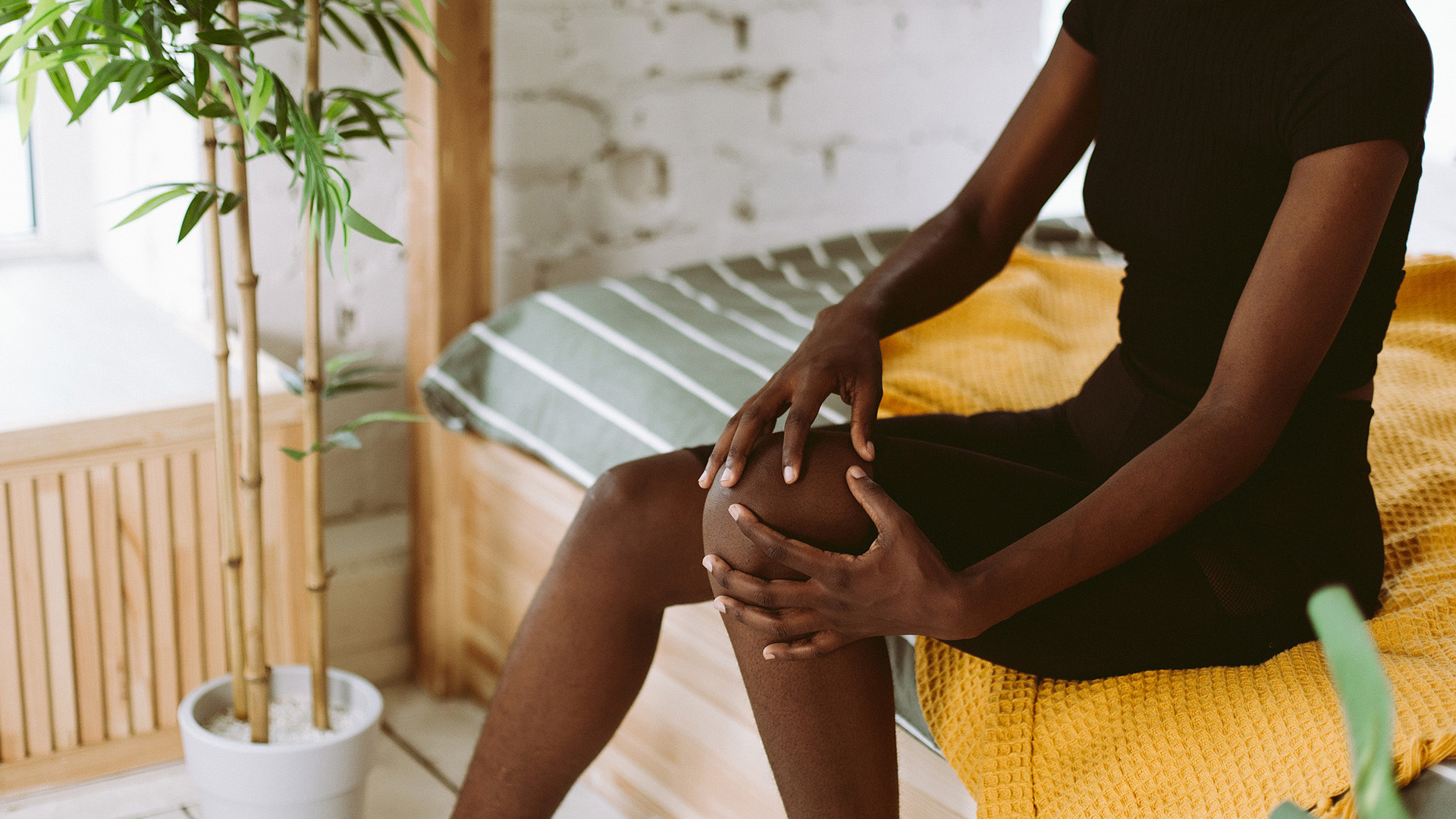 A women massaging kneecap by hands